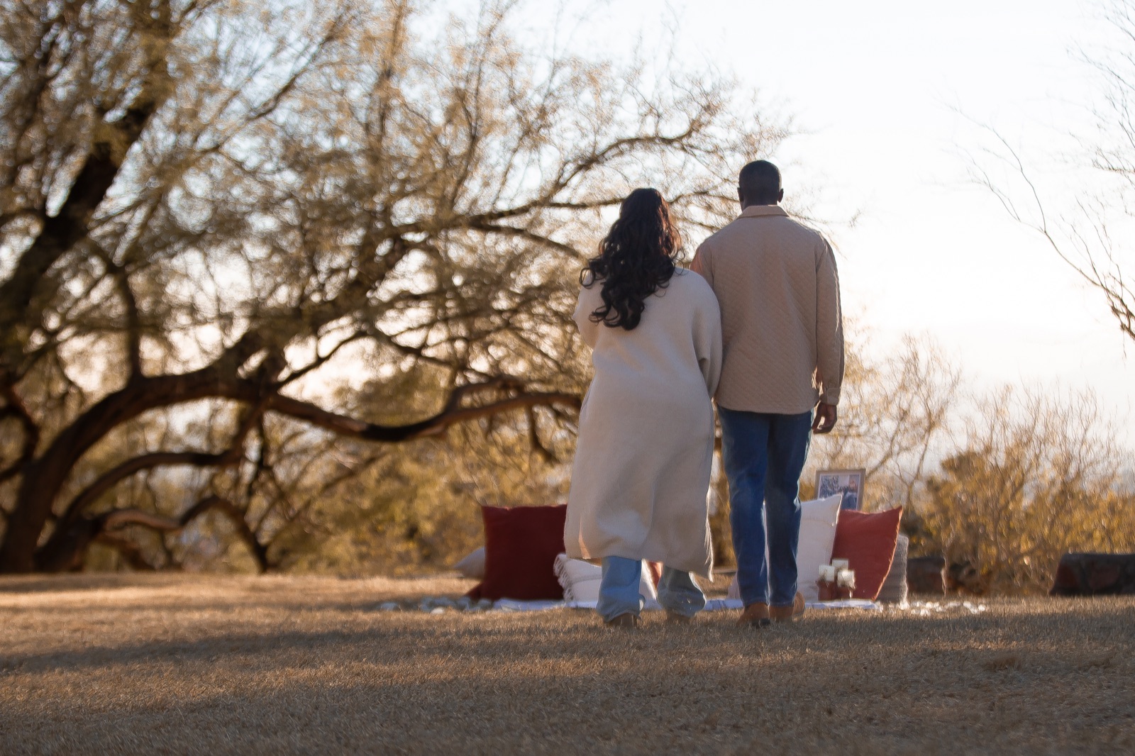 A couple beside a proposal setting at sunset