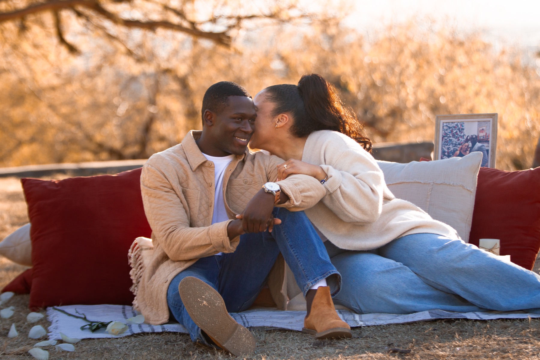 Ayo and Jordin sitting together beside their proposal setting