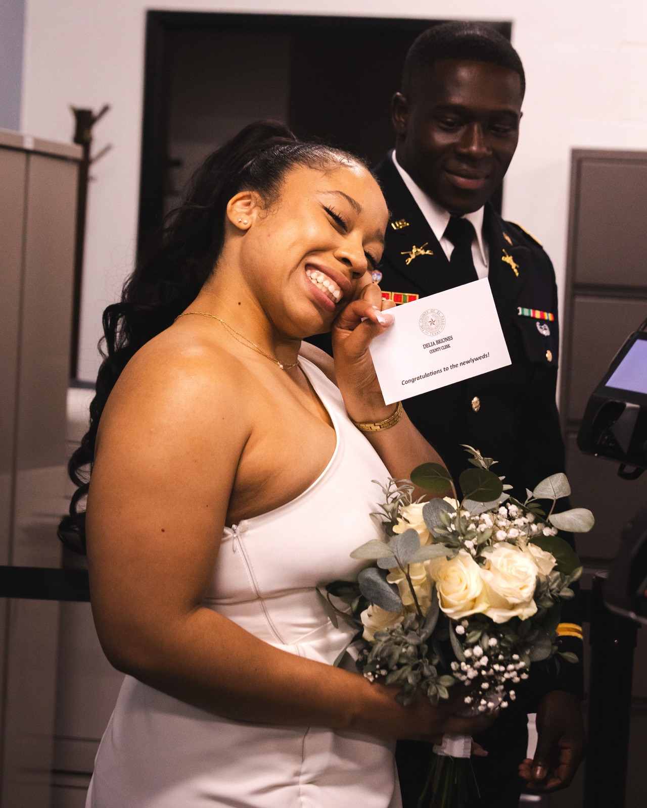 Newlyweds smiling with a bouquet